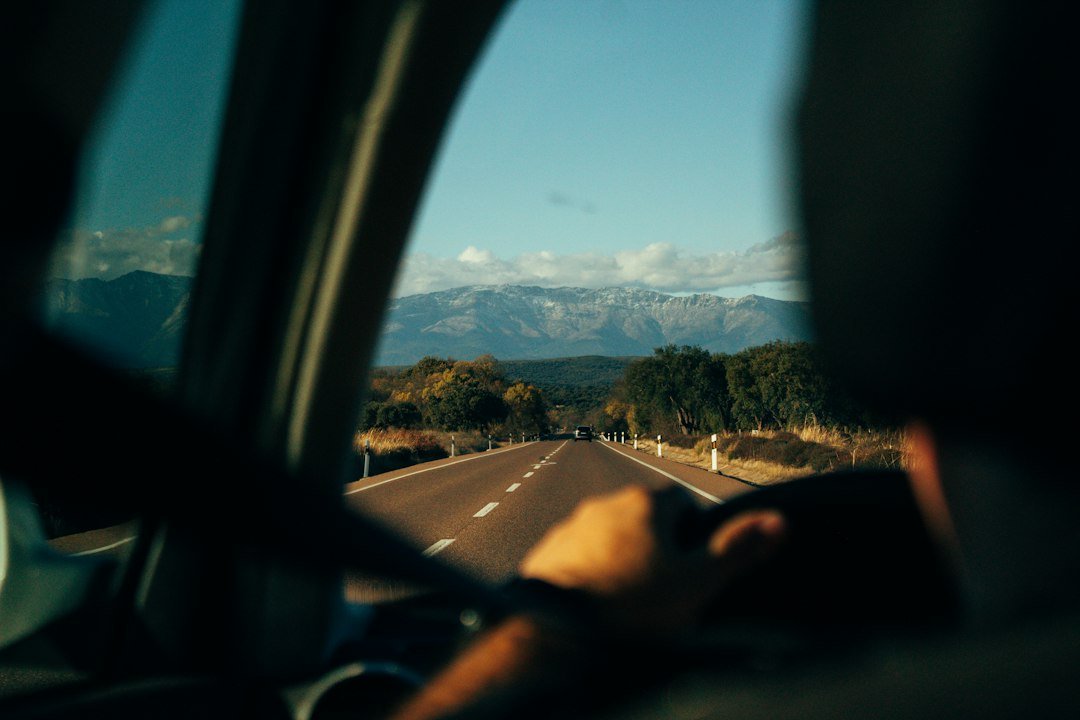 Une personne au volant, vue de l'intérieur. Photo de Manu Mateo, Unsplash.