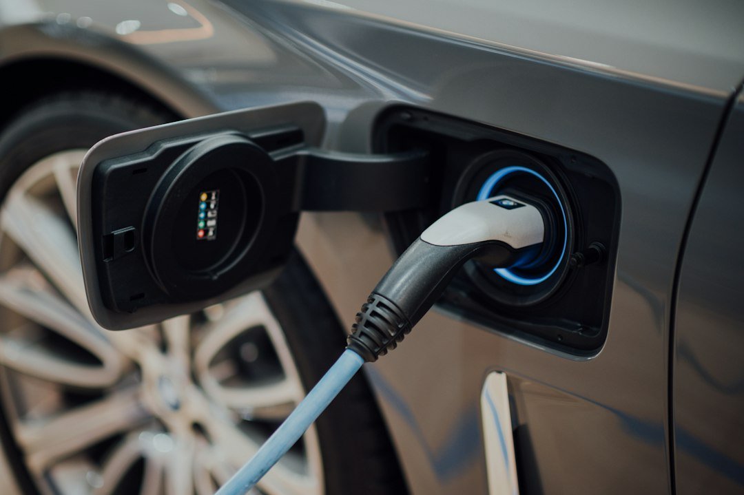 Câble de recharge branché sur une voiture électrique à une borne. Photo de CHUTTERSNAP, Unsplash.