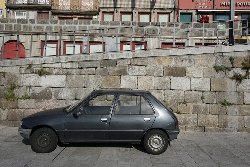 Petite voiture ancienne garée dans une rue. Photo de Sebastien Devocelle, Unsplash.