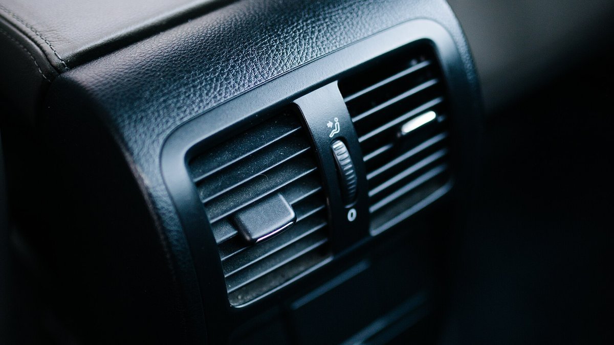 Aérateur noir à lamelles horizontales réglables dans l’habitacle d’une voiture moderne, molette de débit au centre