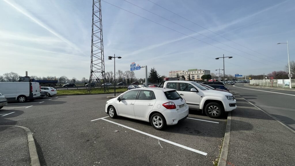 Voitures garées sur une aire de covoiturage en bord de route à Saint-Maurice-de-Beynost, près de Lyon