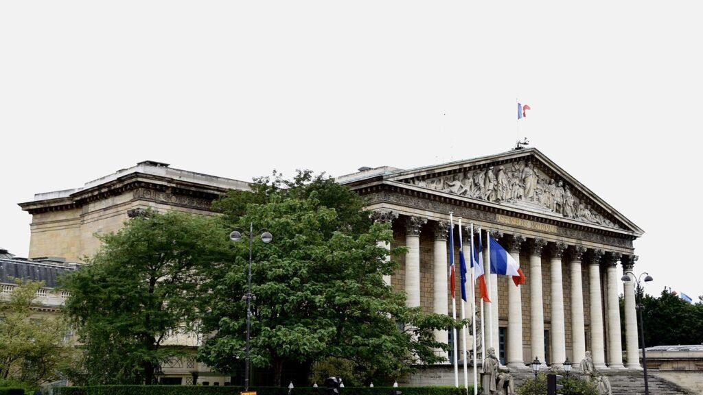 Façade de l'Assemblée nationale (Palais Bourbon) à Paris, vue depuis la Seine, ciel bleu