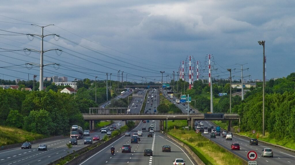 L’autoroute A6 à Wissous, vue vers Paris : trois voies dans chaque sens, des voitures et des camions sous un ciel nuageux