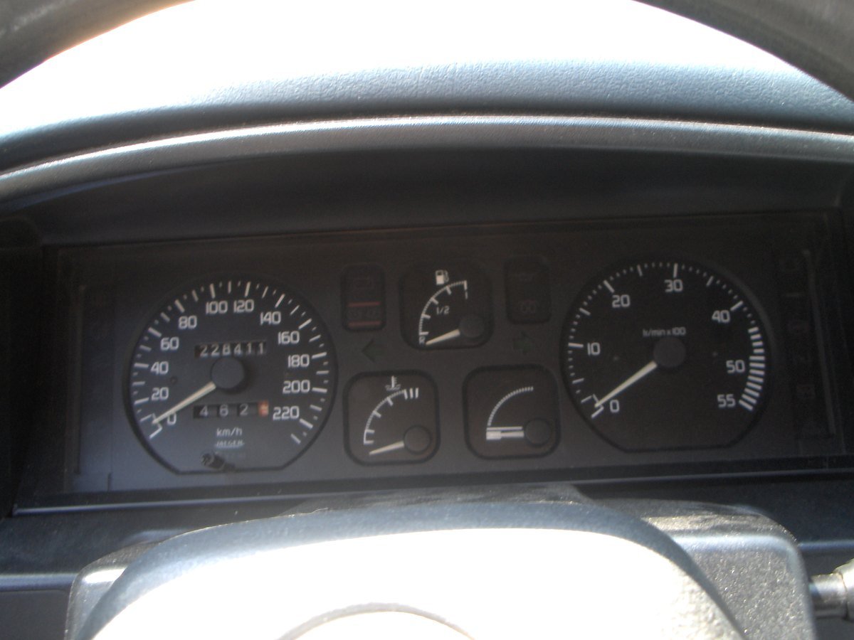Tableau de bord d’une voiture ancienne : compteur kilométrique affichant 228 411 km et totalisateur partiel à 462 km
