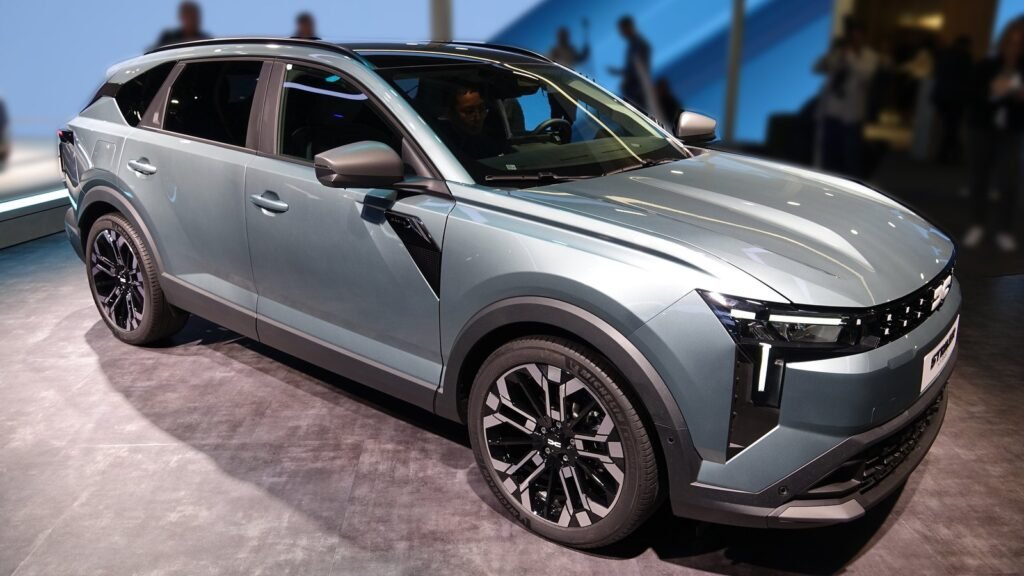 Le Dacia Striker gris-bleu, break surélevé, vu de trois quarts avant sur le stand Dacia du Mondial de l’Auto 2026, visiteurs en arrière-plan