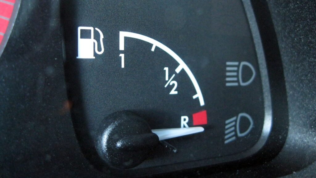 Jauge à carburant analogique d’une Citroën Xsara, aiguille descendue sur la zone rouge marquée R, la réserve, sous les graduations 1 et 1/2
