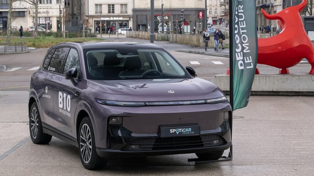 SUV électrique Leapmotor B10 gris-violet vu de trois quarts avant, exposé sur une place de Nancy, logo B10 sur la portière et plaque Spoticar à l’avant