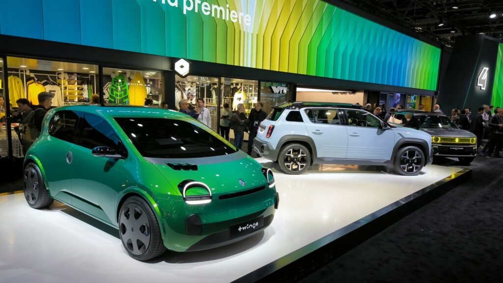 Renault Twingo Electric verte et Renault 4 E-Tech bleue exposées sur un stand du Mondial de l’Auto, illustration des offres électriques au salon