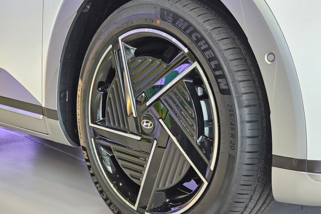 Roue avant d’un Hyundai Ioniq 5 blanc chaussée d’un pneu Michelin Primacy Tour A/S, la dimension 255/45 R 20 lisible sur le flanc