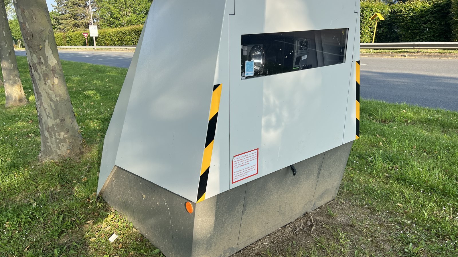 Radar automatique mobile gris aux bandes jaunes et noires posé sur l’herbe au bord de la route D40 à Tremblay-en-France