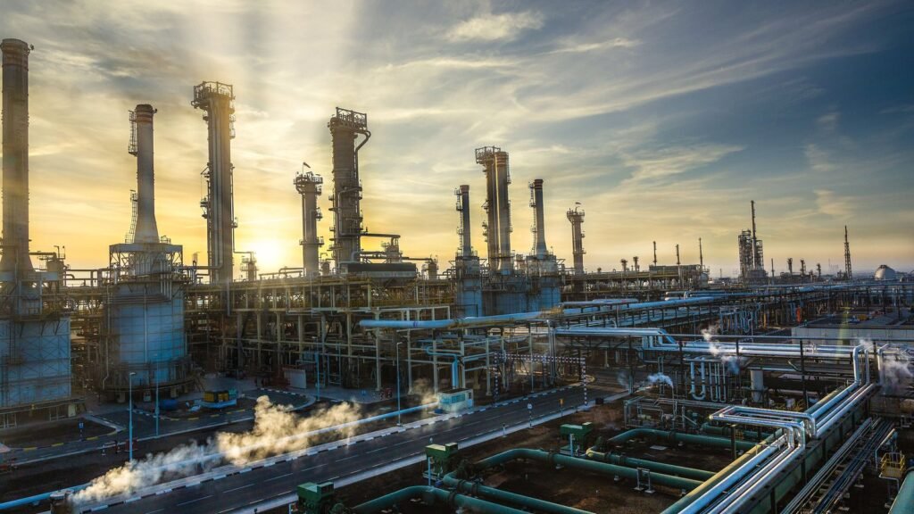 Raffinerie de Ruwais aux Émirats arabes unis au coucher du soleil, avec ses colonnes de distillation, ses cheminées et un réseau de tuyauteries au premier plan