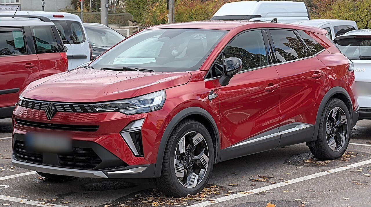 Renault Symbioz rouge garé sur un parking, vu de trois quarts avant