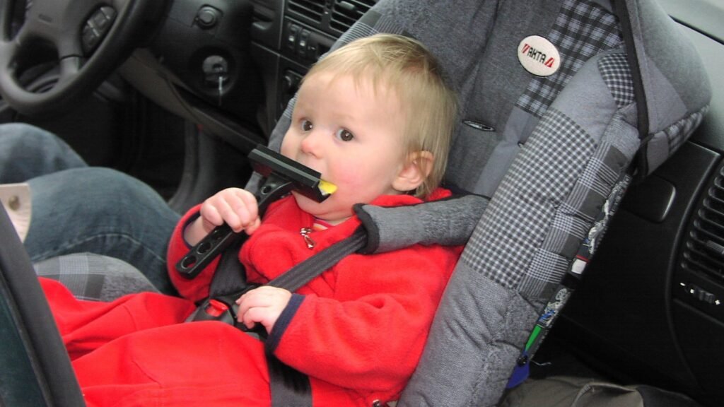 Siège auto bébé installé dos à la route, harnais visible — photo d'illustration