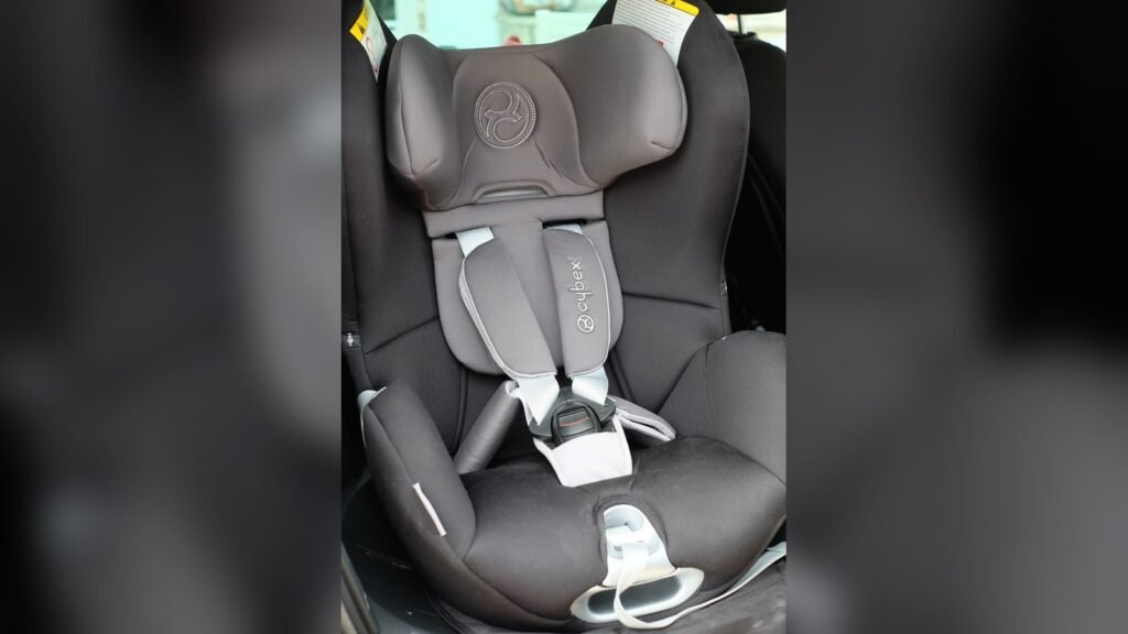 Siège auto pivotant Cybex Sirona gris et noir installé sur un siège de voiture, harnais 5 points et têtière visibles