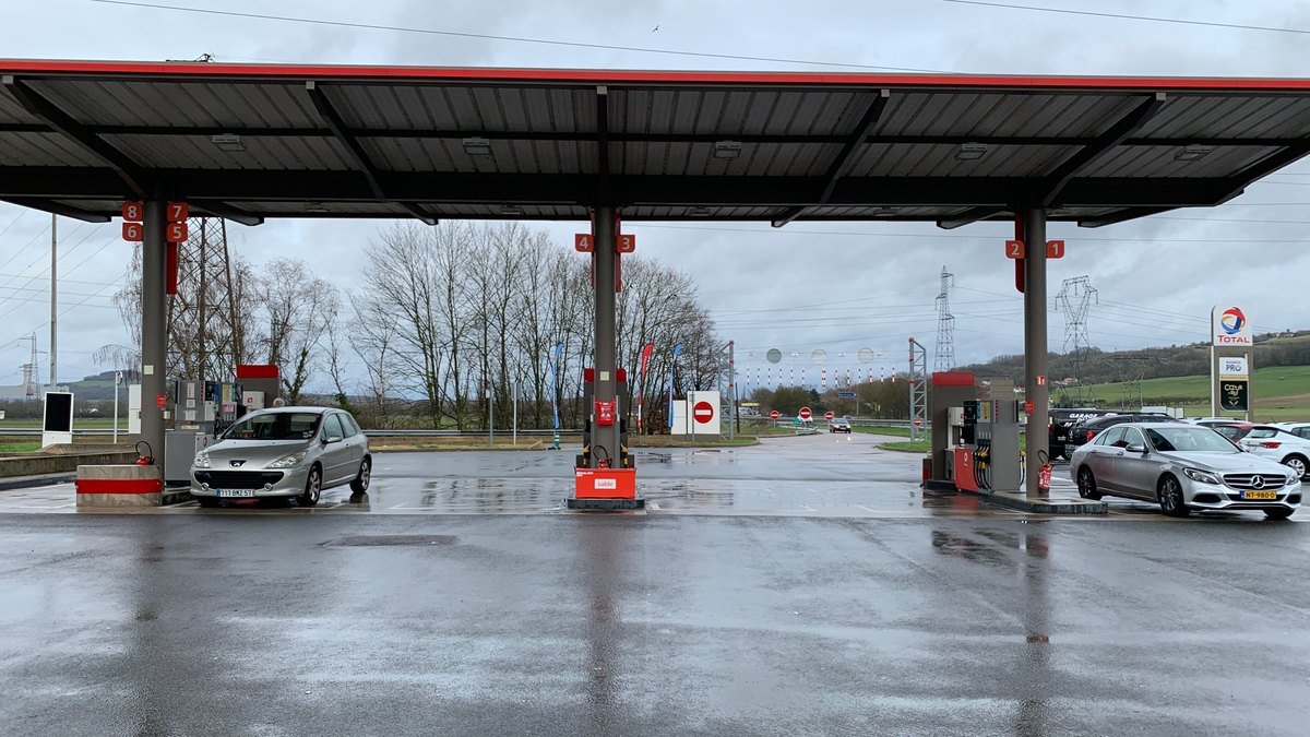 Station-service sur une aire d’autoroute en France, pompes sous un auvent