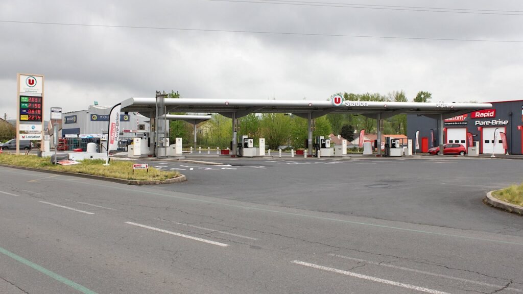 Station-service de grande surface à Cusset, dans l’Allier, avec son totem de prix des carburants et ses pompes sous un auvent, par temps gris