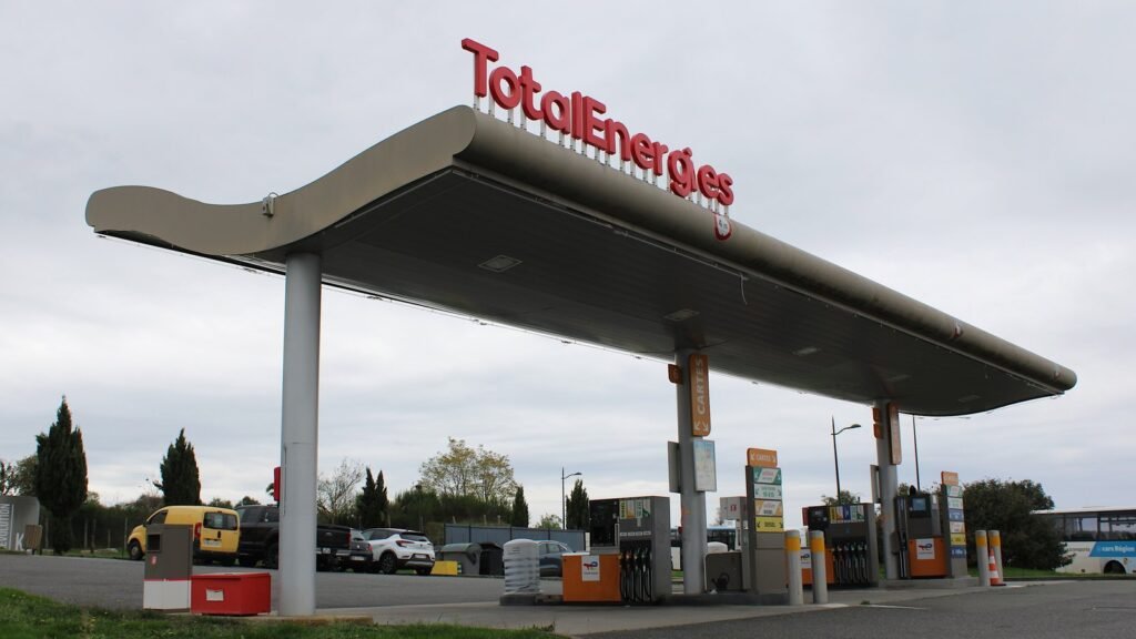 Station-service TotalEnergies à Lapalisse (Allier), avec son auvent et ses pistes de distribution de carburant, des voitures garées derrière